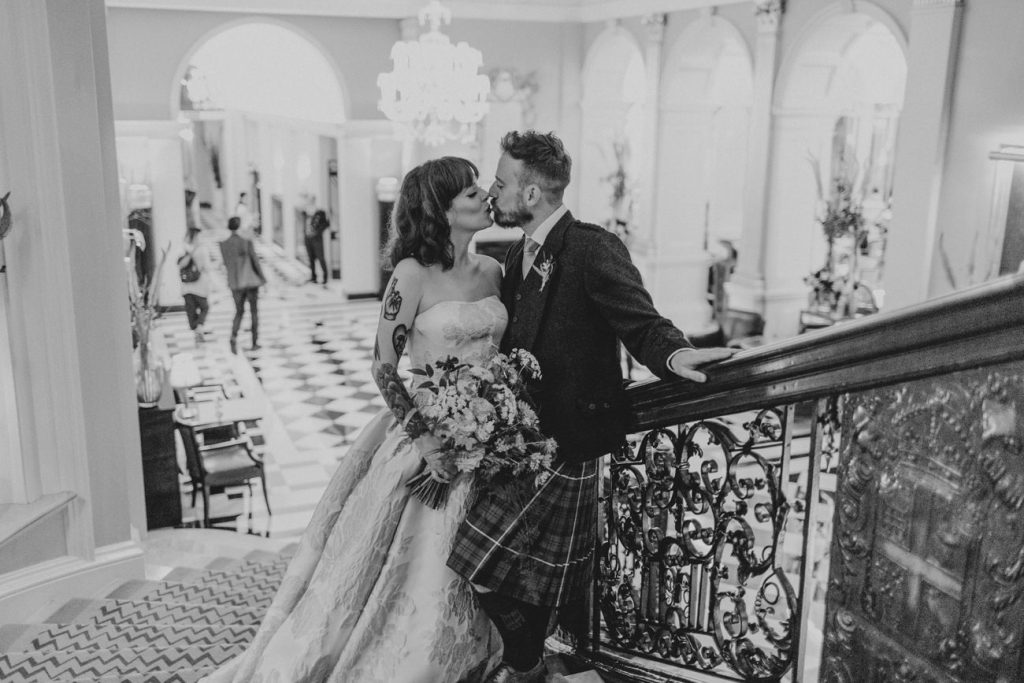 Couple kissing on stairs at Claridges London