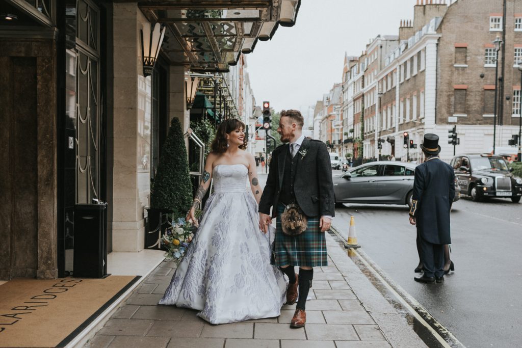 Bride and groom walking down a busy London street