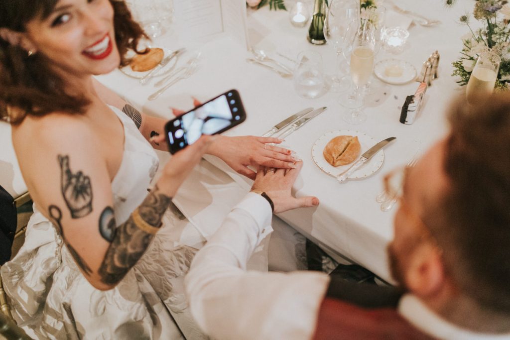 Tattooed bride and groom show off their wedding rings