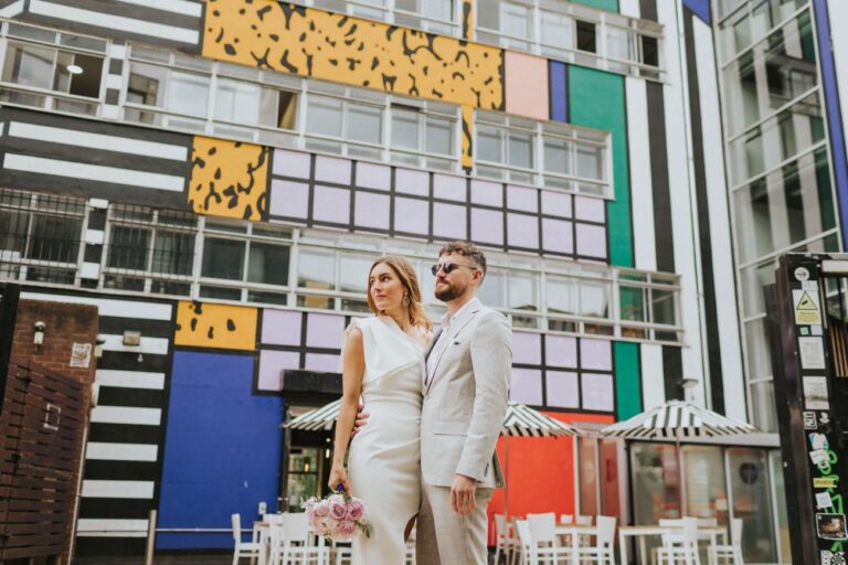 Bride and Groom gazing, in front of street art in Shoreditch London.