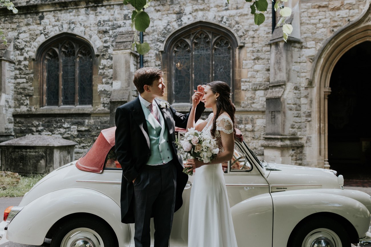 Bride and groom in front of vintage car