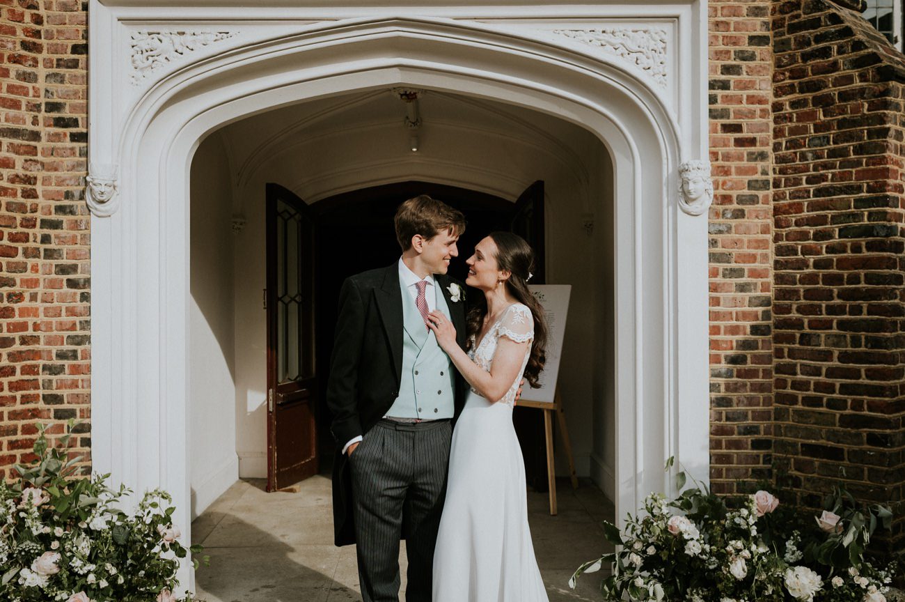 Happy bride and groom portrait in front of Fulham Palace